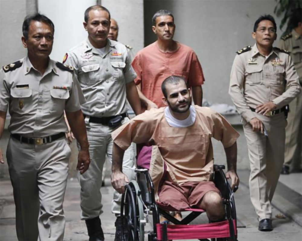 Saeid Moradi, 29, in the wheelchair, and Mohammad Khazaei, 43, are taken to prison